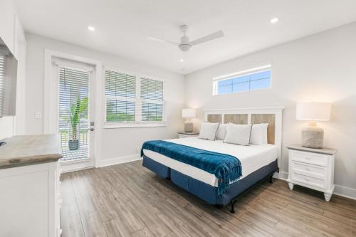a white bedroom with a bed and two windows at Baydream Believer at Hunter's Point in Cortez