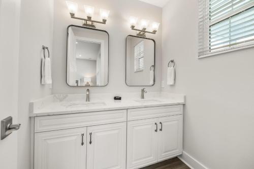 a white bathroom with two sinks and two mirrors at Baydream Believer at Hunter's Point in Cortez