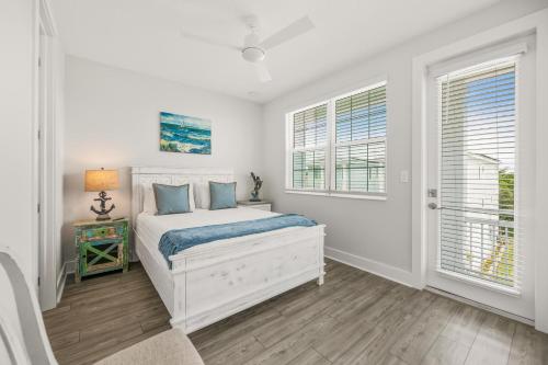 a white bedroom with a bed and two windows at Baydream Believer at Hunter's Point in Cortez