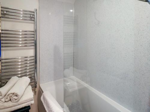 a bathroom with a tub and a glass shower at Daffodil Cottage in Danby