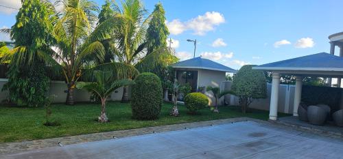 a house with a yard with trees and bushes at Luxury Villa in Beau Vallon