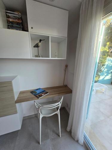 a desk in a room with a chair and a window at Perle d'or vue mer in Saint-Raphaël