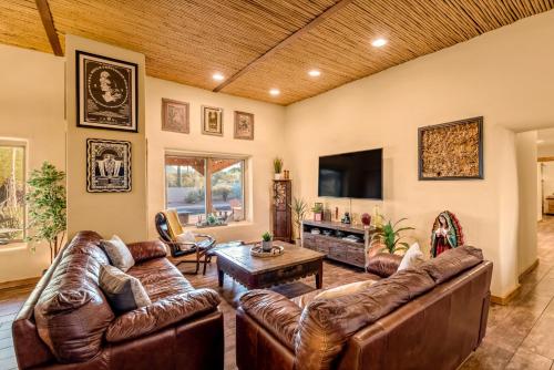 a living room with leather furniture and a flat screen tv at Peaceful Desert Retreat - Stunning Views - Pool Spa, Backyard, Music - Tucson ! in Tucson