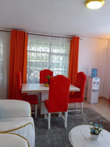 ein Esszimmer mit roten Stühlen und einem Tisch in der Unterkunft Diana executive residents in Kisumu
