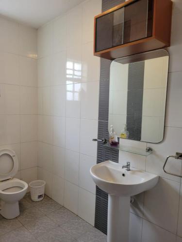 ein Badezimmer mit einem WC, einem Waschbecken und einem Spiegel in der Unterkunft Diana executive residents in Kisumu