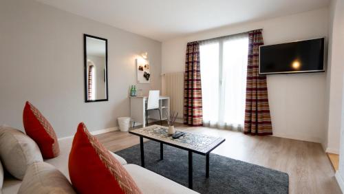 a living room with a couch and a table at Hotel & Restaurant Rössli in Stansstad