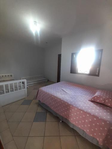 - une chambre avec un lit et une lumière sur le mur dans l'établissement Quarto para temporada, à Ribeirão Preto