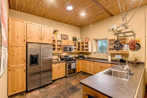 a kitchen with wooden cabinets and a stainless steel refrigerator at Peaceful Desert Retreat - Stunning Views - Pool Spa, Backyard, Music - Tucson ! in Tucson