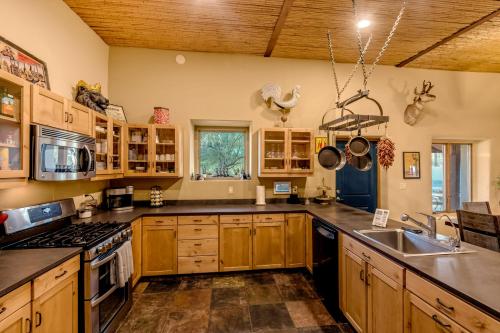 a kitchen with wooden cabinets and a sink at Peaceful Desert Retreat - Stunning Views - Pool Spa, Backyard, Music - Tucson ! in Tucson