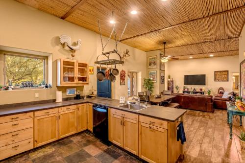 a large kitchen with wooden cabinets and a living room at Peaceful Desert Retreat - Stunning Views - Pool Spa, Backyard, Music - Tucson ! in Tucson