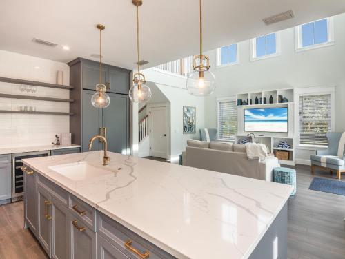 a kitchen with a white counter top and a living room at Luxe Island Escape in Anna Maria