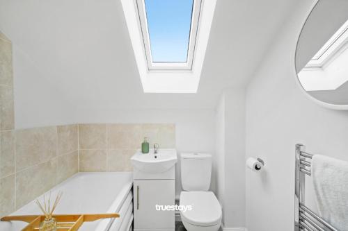 a bathroom with a toilet and a sink and a window at NEW 5 Sarah House by Truestays - 2 Bedroom Apartment - FREE Parking in Manchester