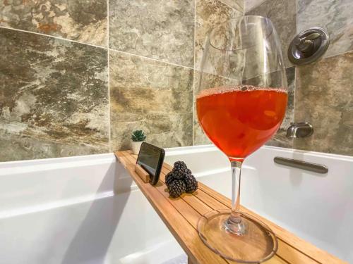 a glass of wine sitting on a wooden tray in a bath tub at Peaceful Desert Retreat - Stunning Views - Pool Spa, Backyard, Music - Tucson ! in Tucson
