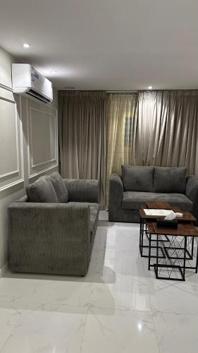 a living room with two couches and a table at حي الورود مقابل برج الخرج in Al Kharj