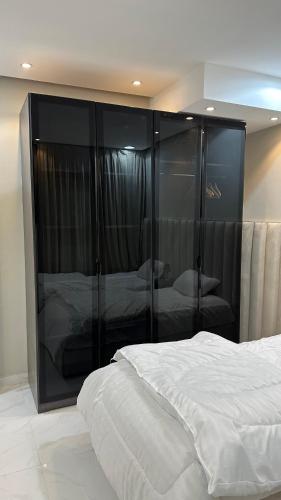 a bedroom with a large bed and a large glass closet at حي الورود مقابل برج الخرج in Al Kharj