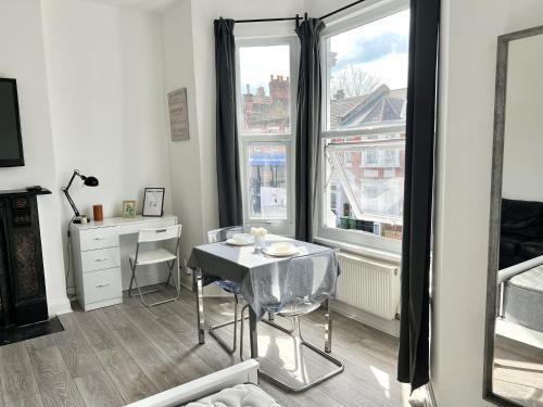 a room with a table and a desk and a window at Westfield London Shepherds Bush in London
