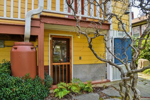 a yellow house with a yellow door and a tree at Zen Studio in Asheville