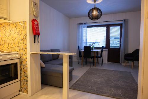 Il comprend une cuisine et un salon avec une table et des chaises. dans l'établissement Cozy Apartment by the Sea, à Kemi