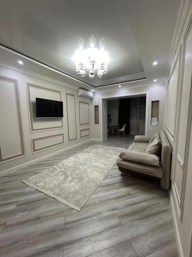 ein Wohnzimmer mit einem Sofa und einem TV in der Unterkunft Люкс 2-х комнатная квартира in Taras