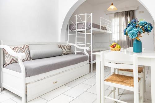 a bedroom with a bunk bed and a table and a desk at Depis studios & apartments in Naxos Chora
