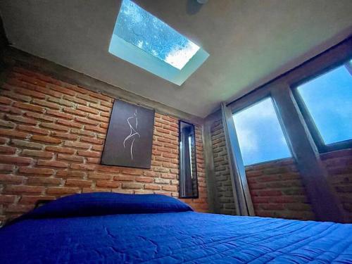 a bedroom with a bed and a brick wall at Cabaña Hermosa Bosque Privado 19 in Mineral del Monte