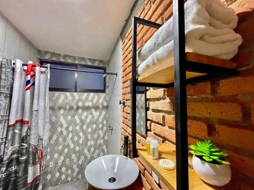 a bathroom with a sink and a brick wall at Cabaña Hermosa Bosque Privado 19 in Mineral del Monte