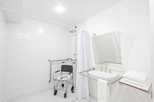 a white bathroom with a walk in shower next to a sink at Slim São Paulo Congonhas in Sao Paulo
