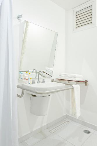 a white bathroom with a sink and a mirror at Slim São Paulo Congonhas in Sao Paulo