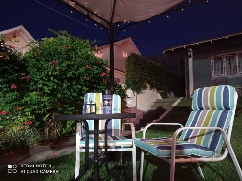 dos sillas y una mesa en un patio por la noche en Hostería Robert en Villa Gesell