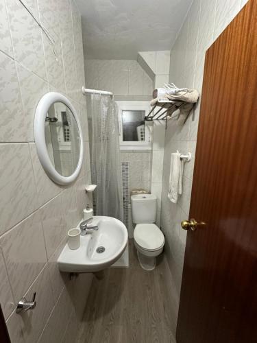 a bathroom with a sink and a toilet and a mirror at A 5 min del aeropuerto + IFEMA in Madrid