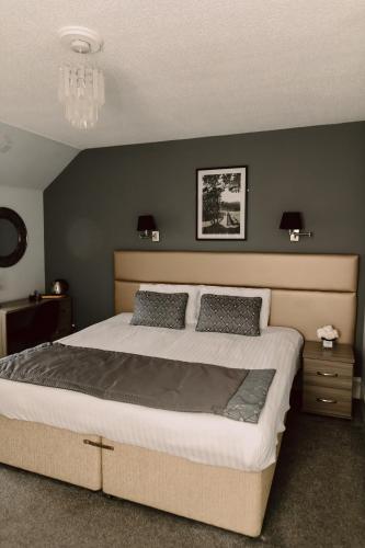a bedroom with a large bed with two pillows at Newmachar Hotel in Newmachar