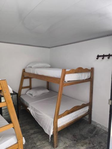 two bunk beds in a room with a white wall at Hotel Palmetto Beach Coveñas in Coveñas