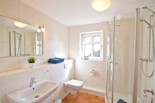 a bathroom with a sink and a toilet and a shower at Haus-Weite-Sicht in Wittdün