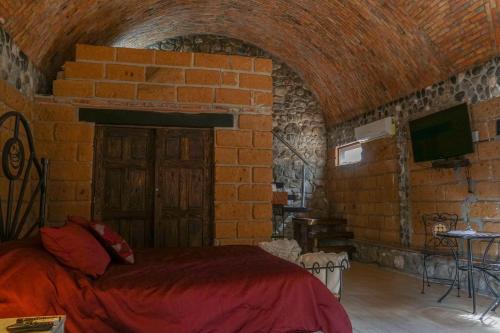 1 dormitorio con 1 cama en una pared de ladrillo en Armadillo Mágico, en Armadillo