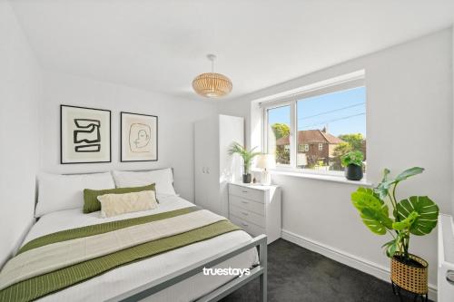 um quarto branco com uma cama e uma janela em NEW 4 Sarah House by Truestays - 2 Bedroom Apartment - FREE Wifi & Parking em Manchester