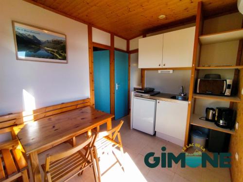 - une cuisine avec une table en bois dans une chambre dans l'établissement Les Chalets du Lac de la Gimone, à Saint-Blancard