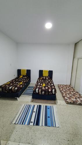 trzy łóżka w pokoju z matami na podłodze w obiekcie Chez lotfi w mieście La Corniche