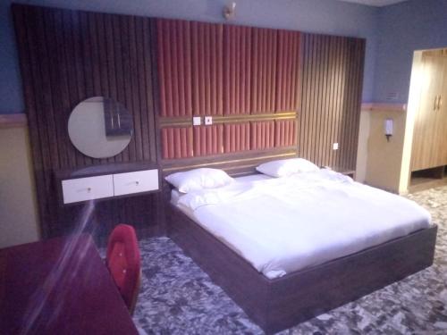 1 dormitorio con cama, mesa y espejo en De Jacob's Hotel & Suites, en Umuinya