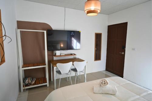 a room with a table and two white chairs at Casita Cumbrera en Penonomé in Penonomé