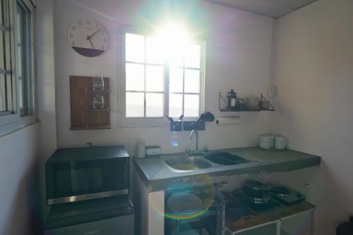 a kitchen with a sink and a clock on the wall at Casita Cumbrera en Penonomé in Penonomé