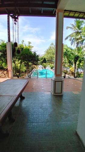 a pavilion with a bench and a swimming pool at Jayaa Villas Bolgoda - Full Villa in Panadura