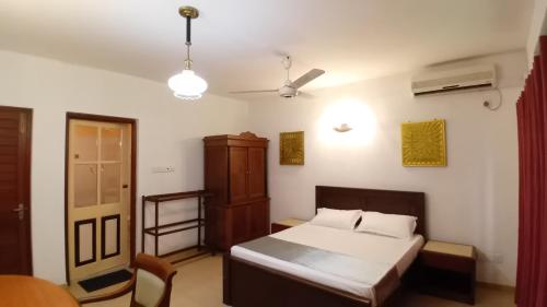 - une chambre avec un lit, une armoire et une fenêtre dans l'établissement Jayaa Villas Bolgoda, à Panadura