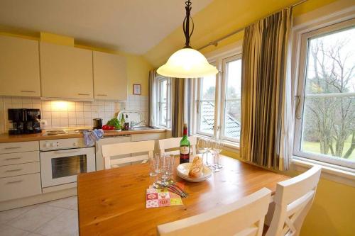 a kitchen with a wooden table with chairs and a dining room at Wohnung-Lee in Nebel