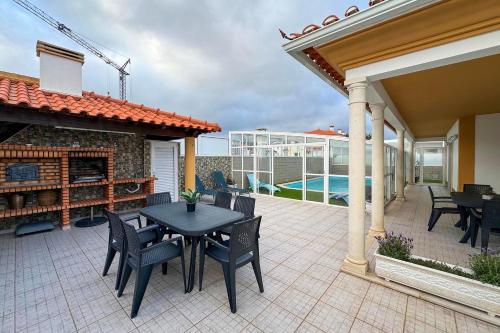 a patio with a table and chairs and a pool at Casa D’Adélia in Nazaré