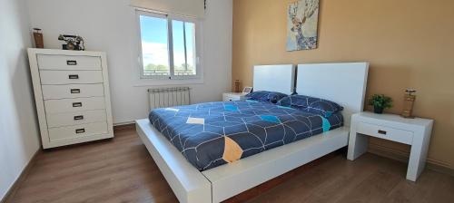 een slaapkamer met een bed met een blauw dekbed bij CasaFamiliar/Tranquilidad25minBCN/BbqPiscinaAAWifi in Rubí