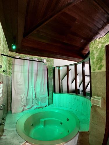 uma casa de banho com uma grande banheira verde num quarto em Pousada Inconfidência Mineira em Ouro Preto