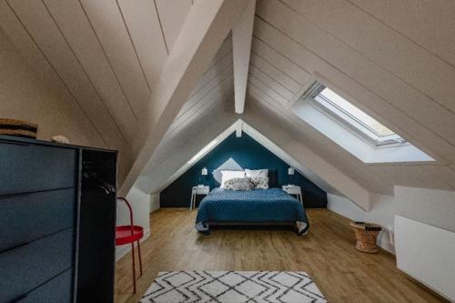 a bedroom with a blue bed in a attic at Refuge de Baden - cadre idyllique 6 pers in Larmor-Baden