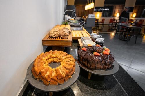 two cakes and other pastries on display in a bakery at Slim São Paulo Congonhas in Sao Paulo