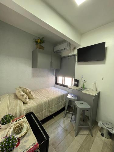 ビセンテ・ロペスにあるEspectacular Departamento en Vicente Lopez ,Avenida San Martín 2248のベッド、デスク、テーブルが備わる小さな客室です。