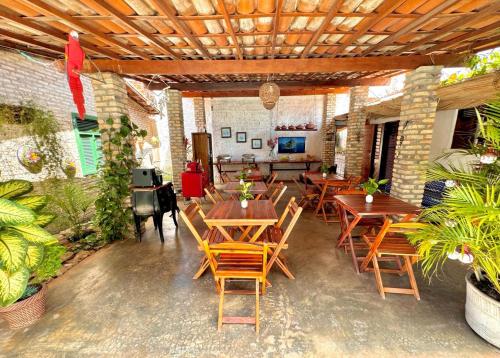 una sala da pranzo con tavoli e sedie in legno di Pousada Flor De Jambú a São Miguel do Gostoso